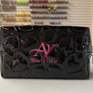 Ann Virtue glossy black cosmetic bag with pink logo